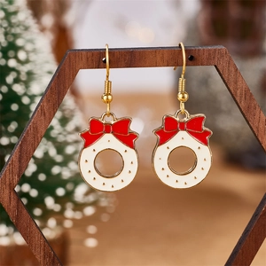 Detail of Christmas wreath earrings with red bows hanging on a wooden hexagonal frame