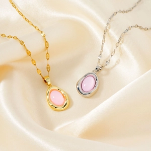 Elegant gold and silver oval pink gemstone pendant necklaces on beige silk fabric