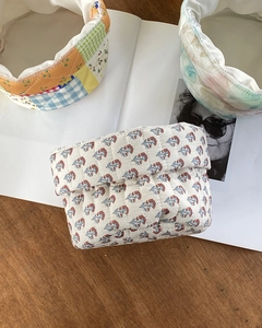 Detailed view of assorted floral quilted cotton organizer bags on a wooden table