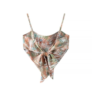 Detail of tie-dye crop top featuring orange and green pattern and back bow tie