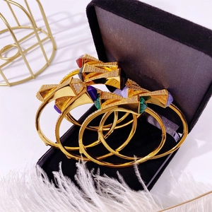 Golden double pagoda bangles with colorful gemstones and rhinestones in a luxury jewelry box