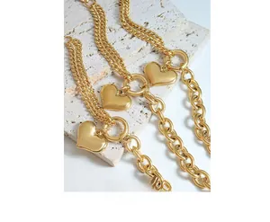 Close-up of three 18K gold plated Cuban link bracelets with smooth heart pendants