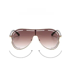 Détail de lunettes de soleil oversize avec verres dégradés marron et monture en métal doré