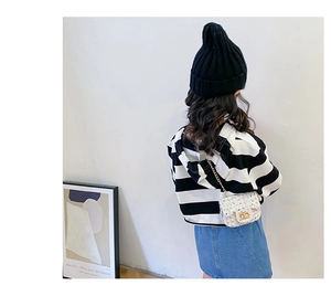 Girl wearing a colorful tweed chain crossbody bag over a striped hoodie and denim skirt