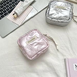 Close-up of quilted heart mini pouch with bow patterns and silk ribbon zipper puller