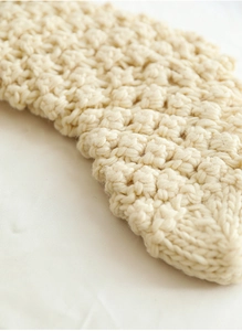 Close-up of cream chunky knit texture on a 46cm Christmas stocking for fireplace decor