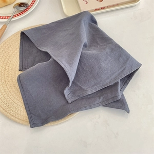 Close-up detail of a grey linen placemat showing the soft textured fabric and natural folds