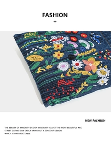 Detailed embroidery featuring sunflowers and butterflies on blue denim fabric texture
