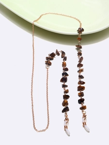 Detailed macro view of natural tiger eye stone beads on a rose gold eyewear chain