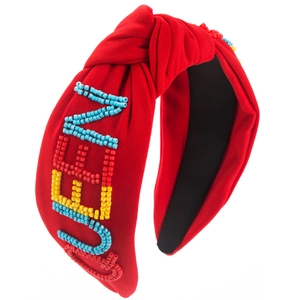 Détail du bandeau en tissu rouge avec inscription QUEEN faite de perles colorées à la main