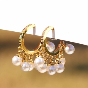 Elegant gold hoop earrings with colorful rhinestones and dangling white pearls on a card