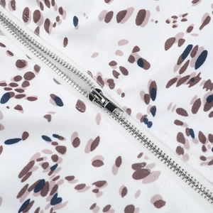 Detailed macro view of high-quality silver metal zipper on printed summer camisole
