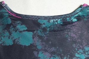 Detailed macro view of the round neckline with mesh tie-dye print and stitched edges