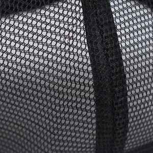 Macro shot of breathable black hexagonal mesh fabric with reinforced stitching on trucker hat