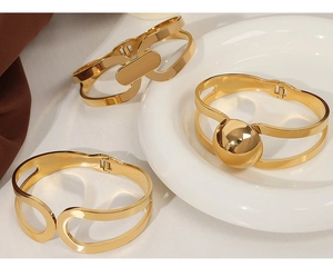 Detailed close-up of three geometric gold-plated titanium steel bracelets in a warm set