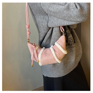 Detail of pink faux suede crescent bag with white plush trim and knot shoulder strap