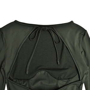 Détail de la robe vert foncé montrant une découpe au dos et un design avec lien à nouer