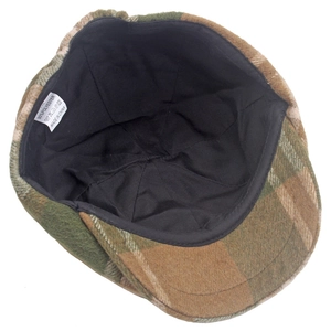 Détail intérieur du béret à carreaux montrant la doublure en laine et l'étiquette de soin