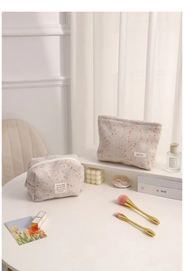 Detail of tweed makeup bags in various sizes with elegant woven texture and zipper