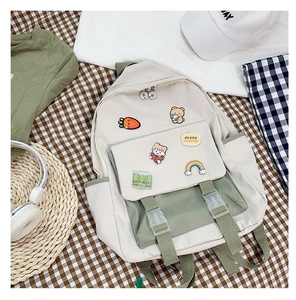 Detail of canvas backpack with cute cartoon badges on green and white patchwork fabric