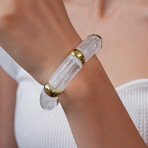 Detailed close-up of acrylic tube bracelet with gold metal spacer beads on a model