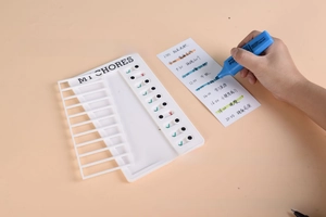 Detail of white My Chores checklist with sliders and handwritten task card with blue pen