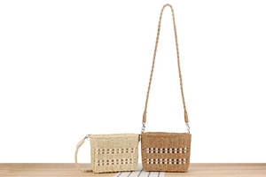Détail de sacs bandoulière en paille tressée beige et marron avec perles