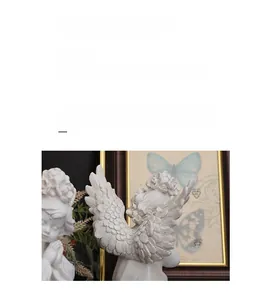 Detailed close-up showing the intricate feather texture of the white resin angel sculpture