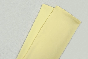 Macro view of pale yellow knit fabric with subtle textures and ribbed details