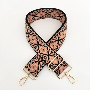 Close-up of geometric ethnic wide guitar strap with pink patterns and gold metal buckles