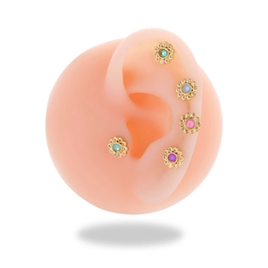 Set of five colorful flower stud earrings with crystals on a realistic ear model