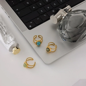 Detailed view of adjustable 18K gold-plated rings with turquoise and green stones