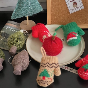 Detail of Christmas knitted ornaments with tree and glove shapes in festive colors