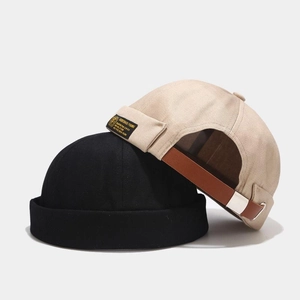 Detail of docker hats featuring adjustable leather straps and metal buckles on back