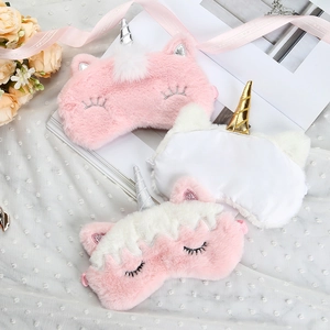 Detailed view of plush unicorn sleep masks with golden horns and embroidered lashes