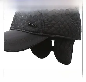 Detail of black quilted winter hat with ear flaps and silver Fashion metal emblem