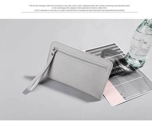 Detail of gray leather clutch with front zipper pocket and matching wrist strap