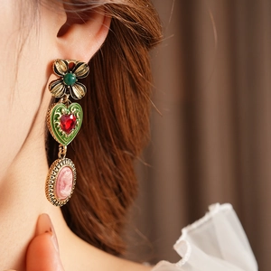 Vue détaillée de boucles d'oreilles vintage en or avec cœurs en émail et reliefs camée