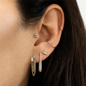 Close-up of gold S925 silver earrings featuring chain tassels and zircon pin studs