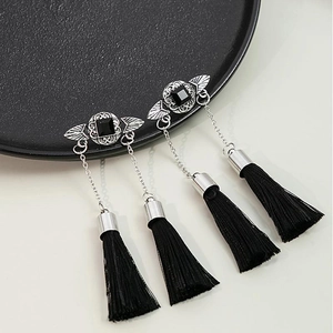 Detail of vintage black tassel earrings with silver hollow metalwork and square stone