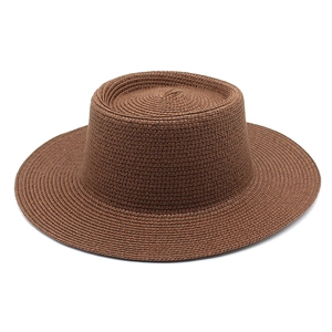 Detailed close-up of woven straw texture and flat crown on caramel brown boater hat