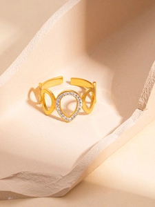 Macro shot of gold hollow water drop ring with sparkling cubic zirconia on stone base