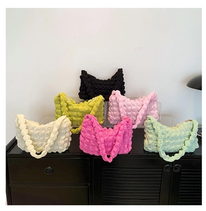 Detailed display of ruched bubble textured hobo bags in six vibrant colors on a retro cabinet