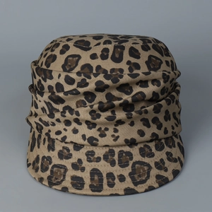 Detail of leopard print newsboy cap showing textured fabric and pleated decorative band