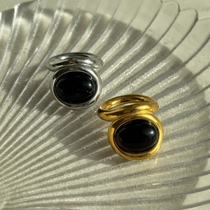 Vintage 18k gold plated titanium steel rings with black oval stones on glass tray