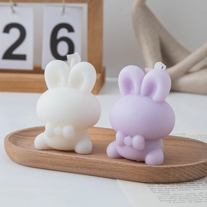 Cute rabbit scented candles in white and lavender on a wooden tray for home decor