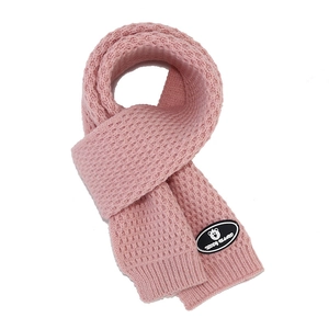 Close-up of pink knitted scarf with thick wool texture and Teddy Island bear logo label