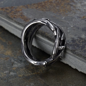 Macro shot of retro stainless steel ring with vintage thorny texture on dark stone surface