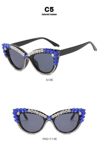 Detail view of cat eye sunglasses with blue gemstones and sparkling white rhinestones