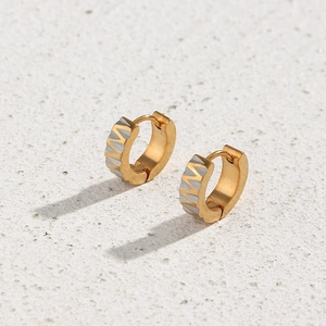 Detailed view of two-tone gold and silver hoop earrings with textured sawtooth pattern